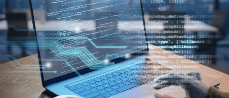 Person coding on a laptop with an overlay showing code, representing application dependencies.