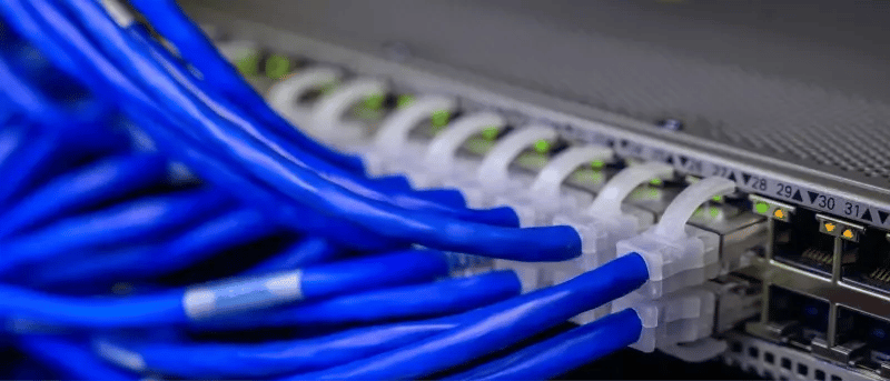 Router or server with connected blue cables, representing deployment assets and environment configurations.